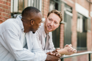 two men, one black one white having a mental health conversation and showing support