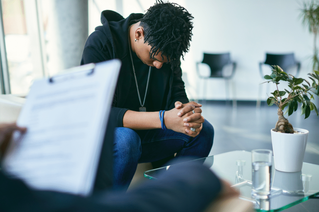 counselling session with a young black man  in some distress